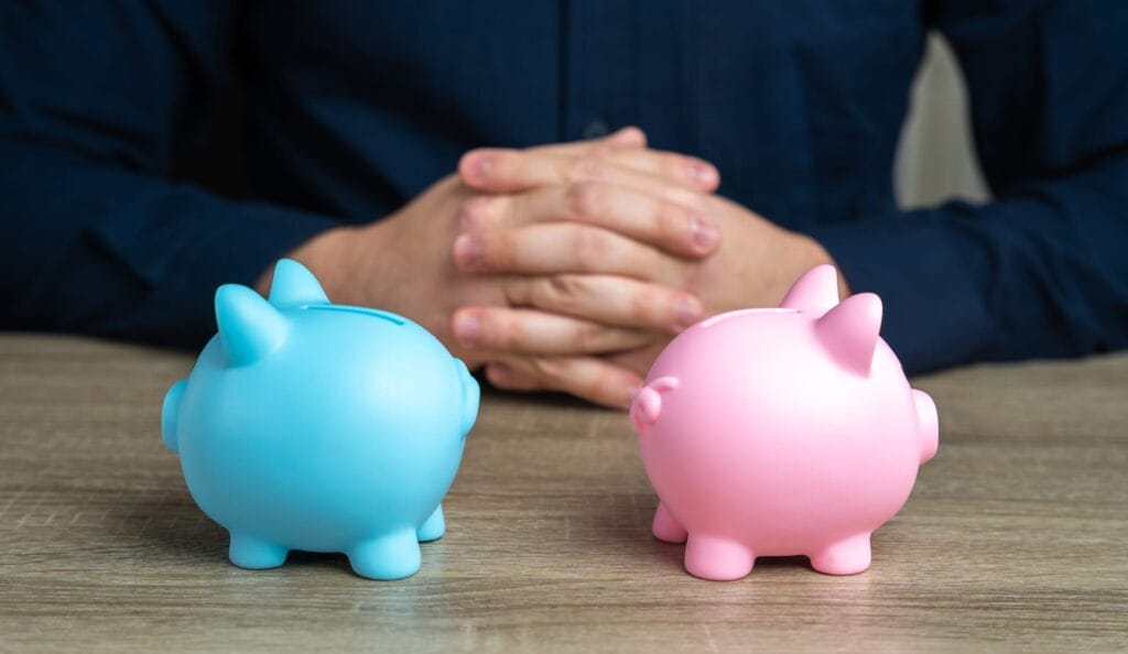 Cash ISAs vs Stocks & Shares ISAs – Which One’s Right for You? 3 Person contemplating two piggy banks, one blue and one pink, symbolising a choice between Cash ISA and Stocks & Shares ISA.
