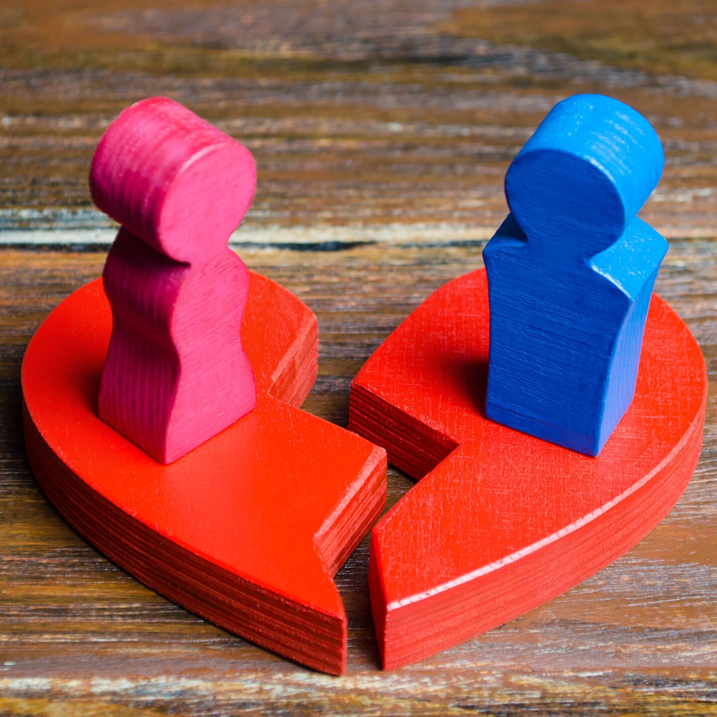 A red broken heart with pink and blue figures to symbolise divorce